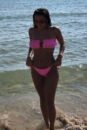 Alexandra wearing a pink bikini near the sea