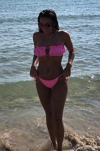 Alexandra wearing a pink bikini near the sea